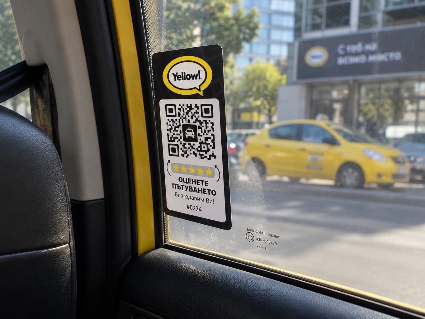 A Yellow! sticker with a QR code for rating the ride, fixed to a taxi window